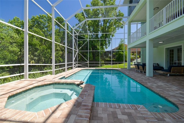view of pool featuring glass enclosure, french doors, a patio area, and a pool with connected hot tub