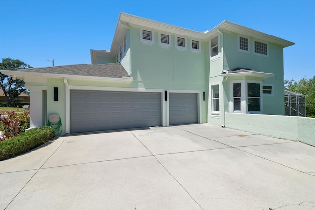 view of front of home with a garage, driveway, and stucco siding