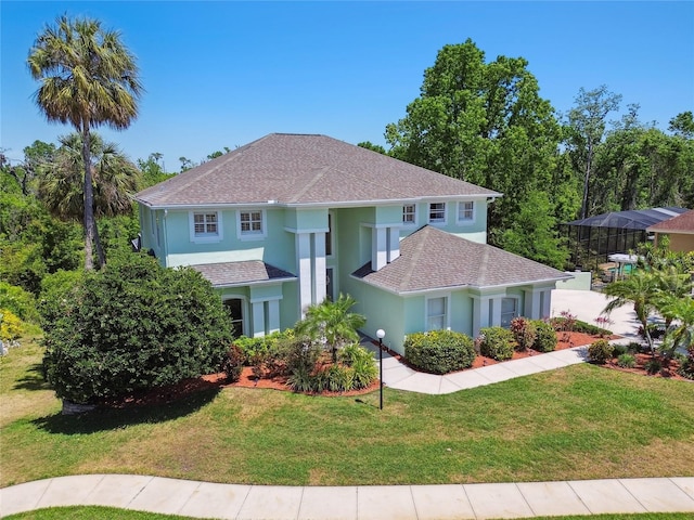 mediterranean / spanish-style house featuring stucco siding, roof with shingles, and a front yard