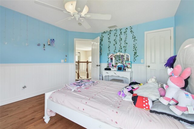 13310 Waterford Run Dr, Riverview, FL 33569 - bedroom featuring wood finished floors, wainscoting, and a ceiling fan