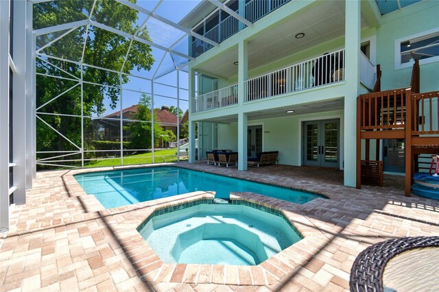 13310 Waterford Run Dr, Riverview, FL 33569 - view of swimming pool with french doors, a pool with connected hot tub, a patio area, and glass enclosure