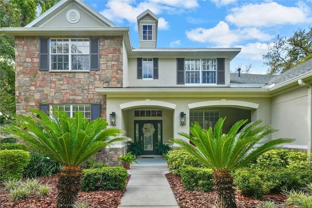 property entrance with stucco siding and stone siding