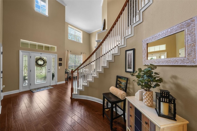 foyer entrance with crown molding, baseboards, stairs, a towering ceiling, and dark wood-type flooring