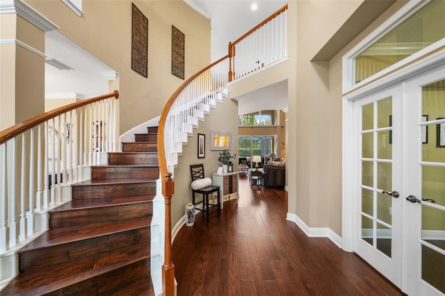 entrance foyer featuring baseboards, hardwood / wood-style flooring, stairway, and french doors