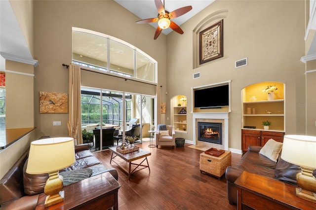 living room featuring a fireplace with flush hearth, visible vents, ceiling fan, and wood finished floors