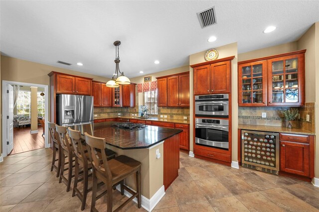 kitchen with a sink, visible vents, wine cooler, and appliances with stainless steel finishes