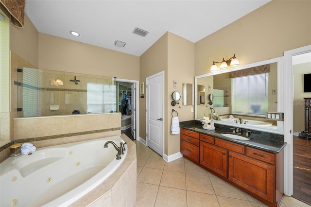 full bath featuring tile patterned flooring, vanity, a jetted tub, visible vents, and tiled shower