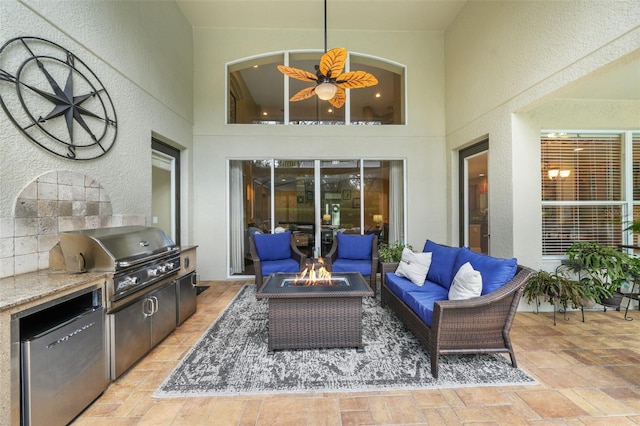 view of patio / terrace with a grill, an outdoor living space with a fire pit, and area for grilling