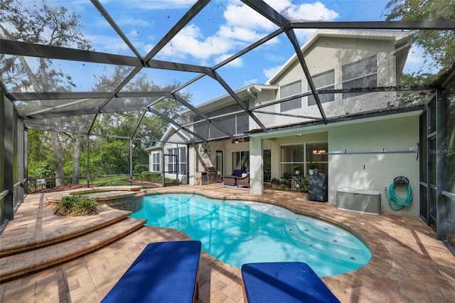 view of swimming pool with a patio, a pool with connected hot tub, and glass enclosure