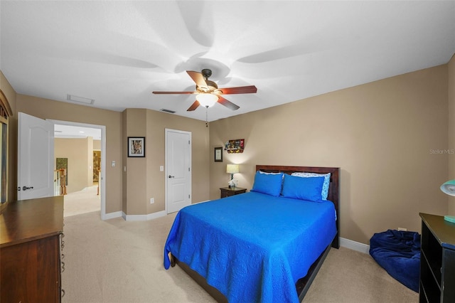 bedroom featuring baseboards, ceiling fan, visible vents, and light colored carpet