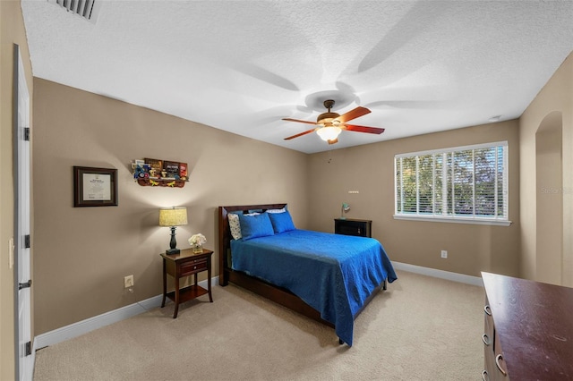 bedroom featuring visible vents, baseboards, light colored carpet, and a textured ceiling