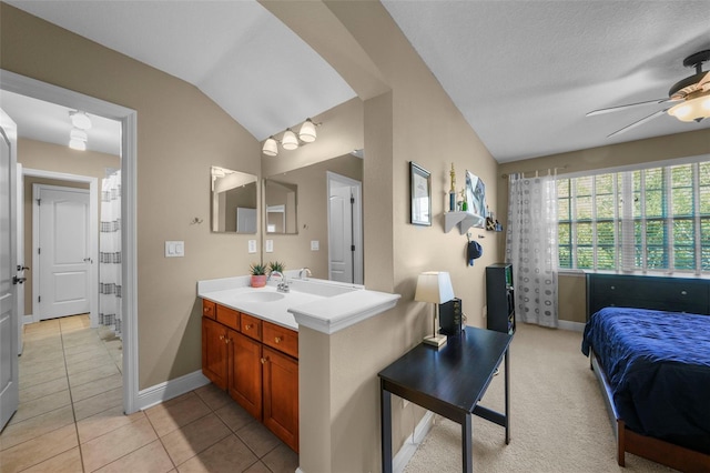 full bath with a ceiling fan, vanity, tile patterned floors, and vaulted ceiling