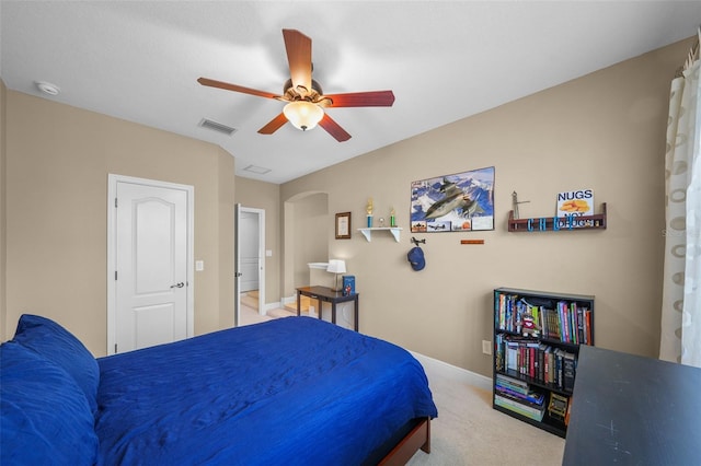 bedroom with light colored carpet, baseboards, arched walkways, ceiling fan, and visible vents