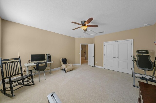 office area featuring a textured ceiling, visible vents, baseboards, ceiling fan, and carpet floors