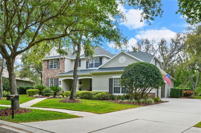 view of front of home with stone siding, concrete driveway, stucco siding, a front lawn, and a garage
