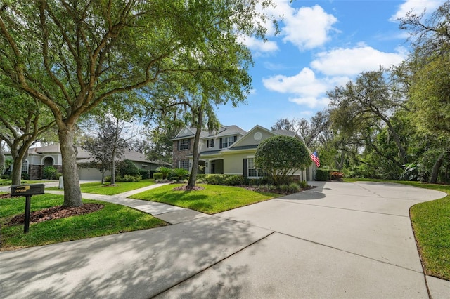 view of front of house with a front yard and curved driveway