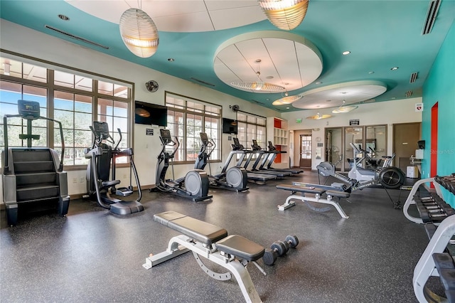 exercise room with a wealth of natural light, visible vents, and baseboards