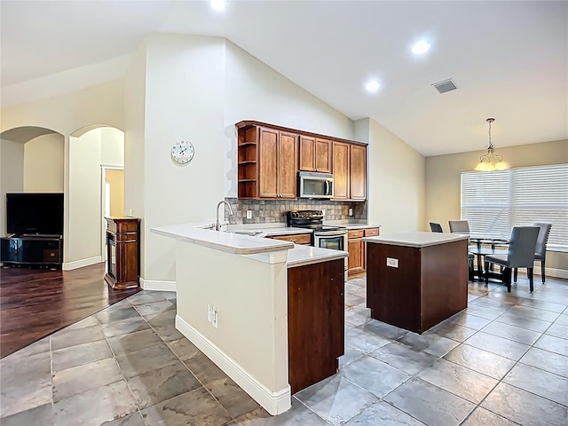 kitchen featuring a center island, open shelves, a sink, appliances with stainless steel finishes, and visible vents