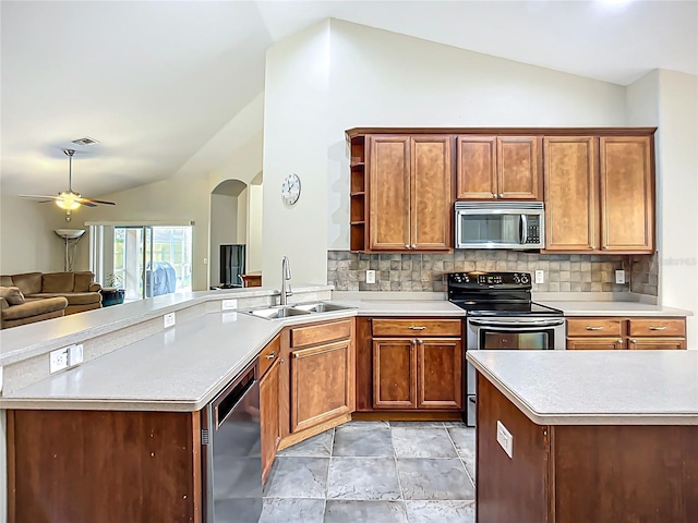 kitchen featuring open shelves, vaulted ceiling, stainless steel appliances, and a sink