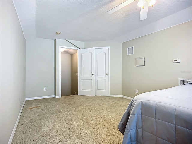 bedroom with carpet, visible vents, baseboards, a textured ceiling, and ceiling fan