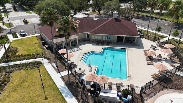 pool with a patio and fence