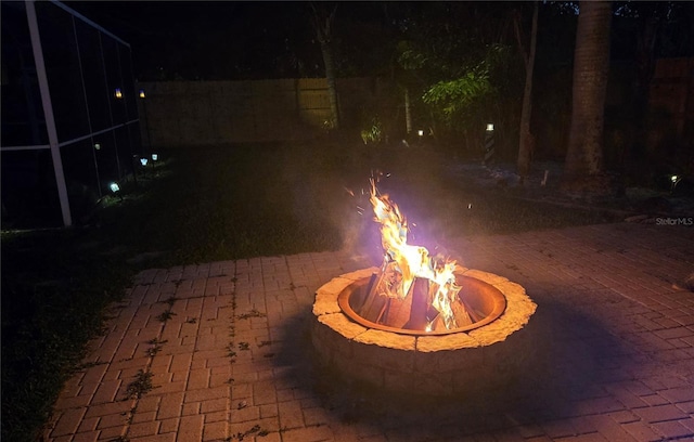 patio at night featuring an outdoor fire pit
