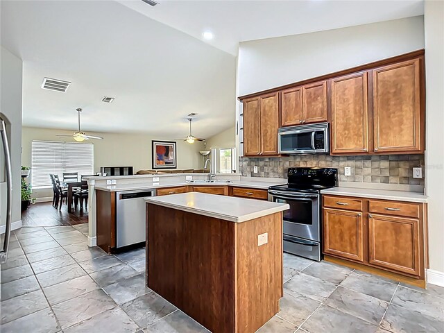 kitchen with a ceiling fan, decorative backsplash, stainless steel appliances, a peninsula, and visible vents