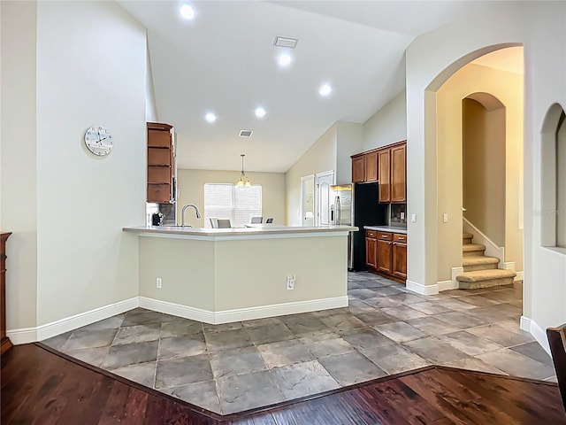 kitchen featuring open shelves, vaulted ceiling, visible vents, baseboards, and a peninsula