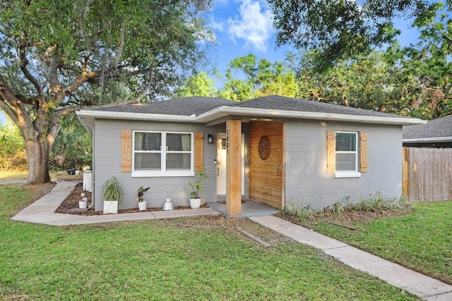 2001 E Idlewild Ave, Tampa, FL 33610 - bungalow-style home featuring concrete block siding, fence, and a front lawn