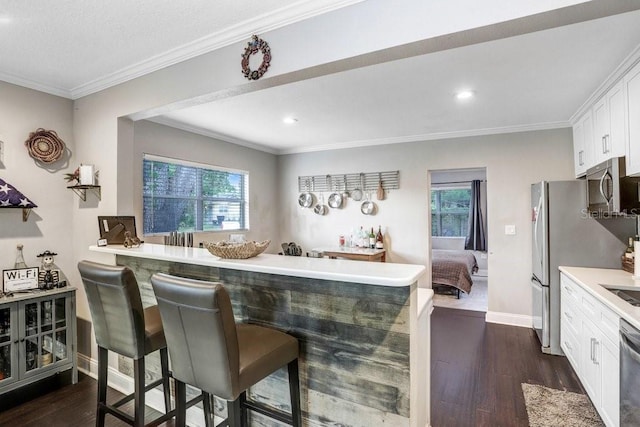 2001 E Idlewild Ave, Tampa, FL 33610 - kitchen featuring a kitchen bar, plenty of natural light, appliances with stainless steel finishes, and dark wood-type flooring