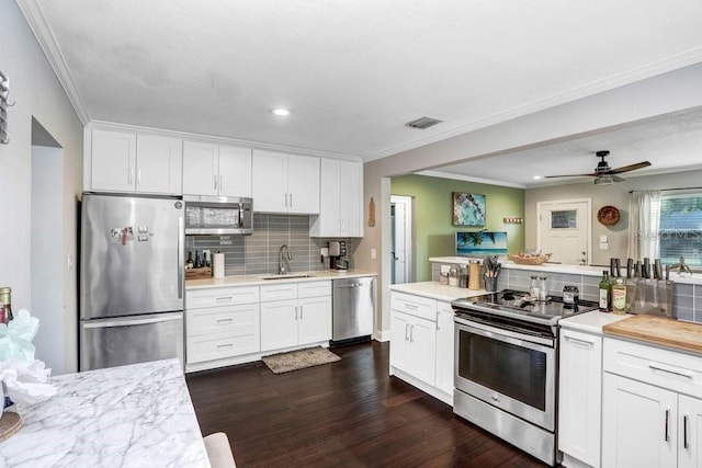 2001 E Idlewild Ave, Tampa, FL 33610 - kitchen featuring light countertops, stainless steel appliances, white cabinetry, a sink, and dark wood-style floors