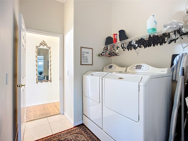 3625 Gaviota Dr, Ruskin, FL 33573 - clothes washing area with baseboards, washer and clothes dryer, laundry area, and light tile patterned floors
