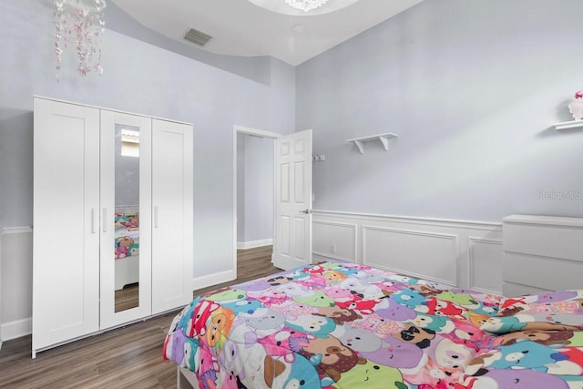 14521 Mirasol Manor Ct, Tampa, FL 33626 - bedroom with wood finished floors, wainscoting, a closet, a high ceiling, and baseboards