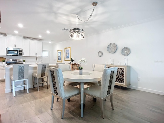 17228 Holly Well Ave, Wimauma, FL 33598 - dining area featuring crown molding, light wood-type flooring, and recessed lighting