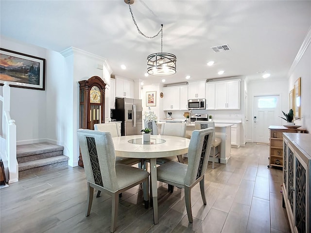 17228 Holly Well Ave, Wimauma, FL 33598 - dining room with crown molding, a chandelier, recessed lighting, stairway, and light wood-style floors