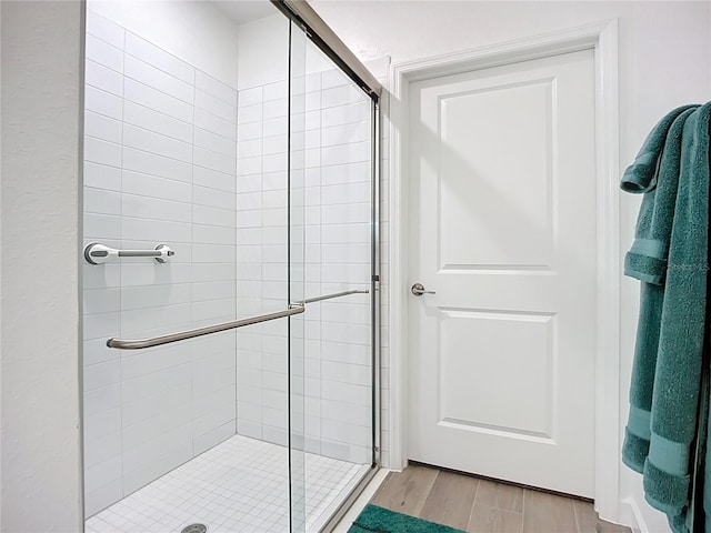17228 Holly Well Ave, Wimauma, FL 33598 - bathroom featuring a stall shower and wood finished floors