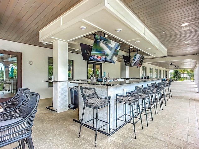 17228 Holly Well Ave, Wimauma, FL 33598 - kitchen featuring dark countertops, a kitchen breakfast bar, wooden ceiling, recessed lighting, and light floors