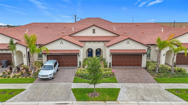 17228 Holly Well Ave, Wimauma, FL 33598 - mediterranean / spanish house with driveway, an attached garage, stucco siding, and a tiled roof