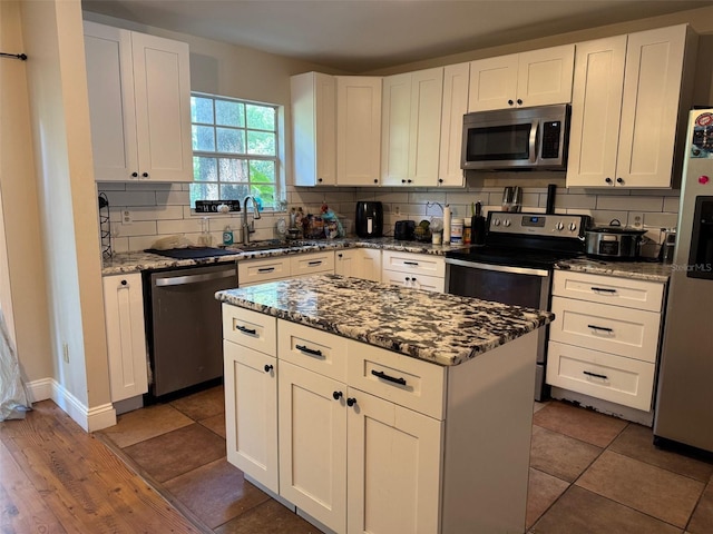 665 Oak Harbour Dr Unit 115, Altamonte Springs, FL 32701 - kitchen featuring appliances with stainless steel finishes, decorative backsplash, stone counters, and white cabinetry