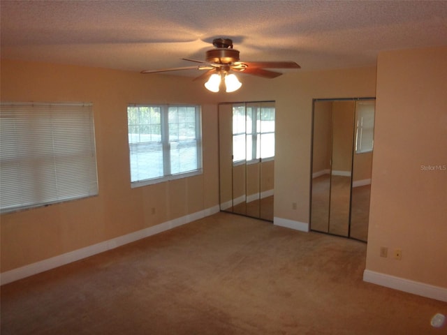 665 Oak Harbour Dr Unit 115, Altamonte Springs, FL 32701 - unfurnished bedroom with baseboards, carpet flooring, a textured ceiling, two closets, and ceiling fan