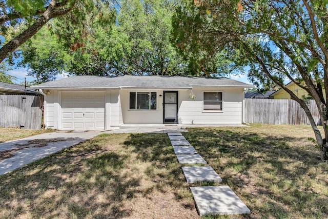 129 NW Lincoln Cir N, Saint Petersburg, FL 33702 - ranch-style home featuring an attached garage, driveway, fence, and a front lawn
