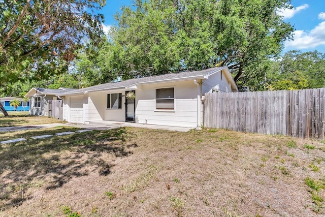 129 NW Lincoln Cir N, Saint Petersburg, FL 33702 - view of front of property with an attached garage, fence, and a front yard