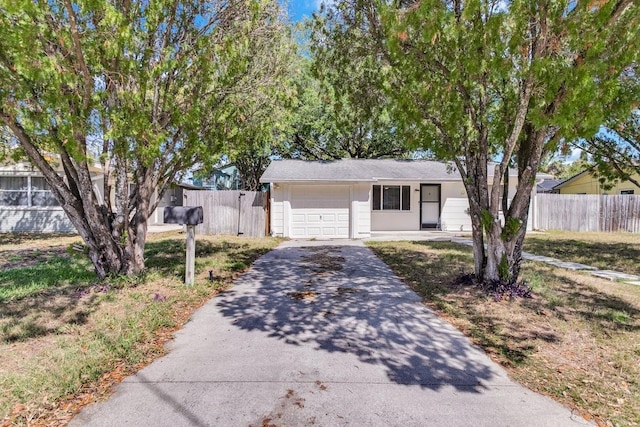 129 NW Lincoln Cir N, Saint Petersburg, FL 33702 - ranch-style house featuring an attached garage, aphalt driveway, and fence