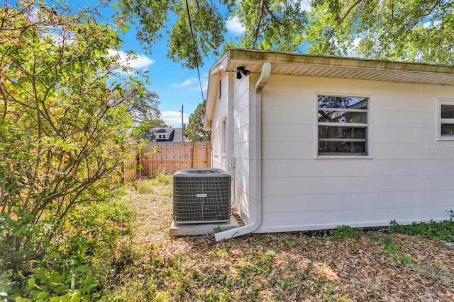 129 NW Lincoln Cir N, Saint Petersburg, FL 33702 - view of property exterior with central air condition unit and fence
