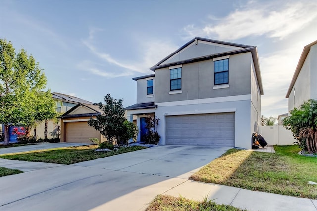 traditional-style house featuring an attached garage, fence, driveway, and stucco siding