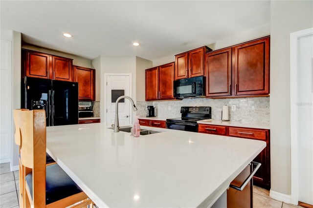 kitchen featuring a sink, backsplash, light countertops, and black appliances