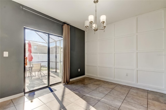 unfurnished dining area featuring a decorative wall, light tile patterned floors, baseboards, and an inviting chandelier