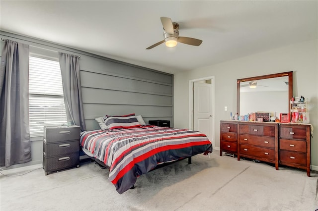 bedroom with light colored carpet, ceiling fan, and baseboards