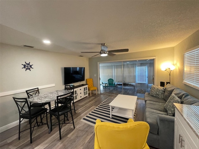living area featuring wood finished floors, a ceiling fan, baseboards, and healthy amount of natural light