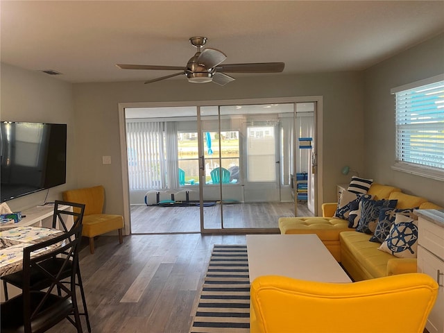living area with wood finished floors and a ceiling fan
